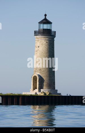 The Lake St. Clair, Michigan lighthouse with a lake freighter passing ...