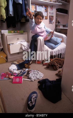 young girl ordering onlooker to get out of her messy bedroom Stock Photo