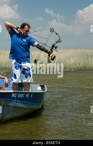 Man drawing his compound bow and aiming at a fish Stock Photo - Alamy