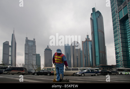 Shanghai Pudong commercial district high rise office buildings and street cleaner foreground with passing roadway traffic moving in background Stock Photo