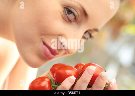 Woman Sniffing Plum Tomatoes Model Released Stock Photo