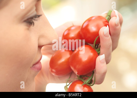 Woman Sniffing Plum Tomatoes Model Released Stock Photo