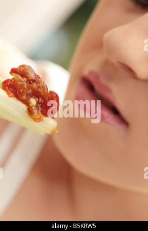 Young Woman Eating Celery with Salsa Model Released Stock Photo