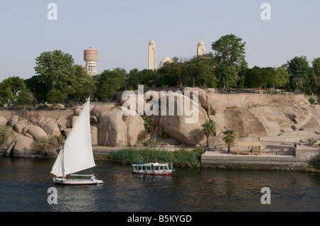 A tour boat and a traditional Felucca boat sailing on the Nile river in Aswan Egypt Stock Photo