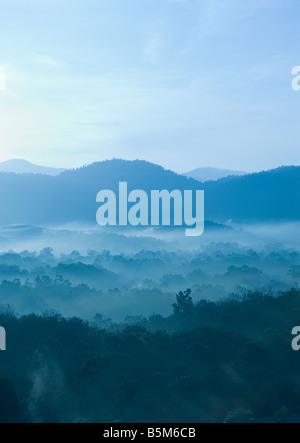 Misty morning of hilly area with ray of light Stock Photo