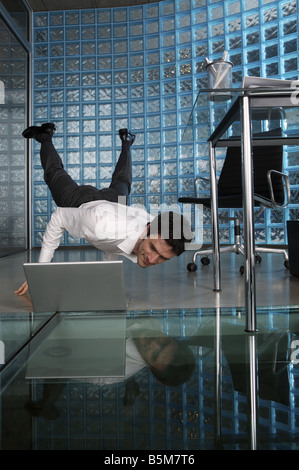 Businessman practicing yoga at the office Stock Photo