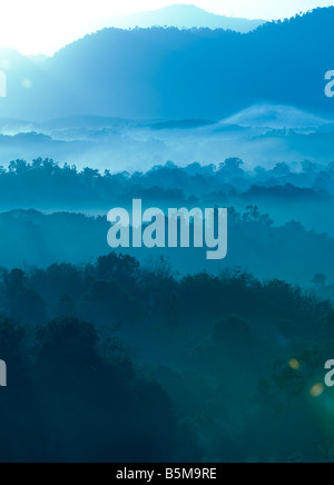 Misty morning of hilly area with ray of light. Stock Photo