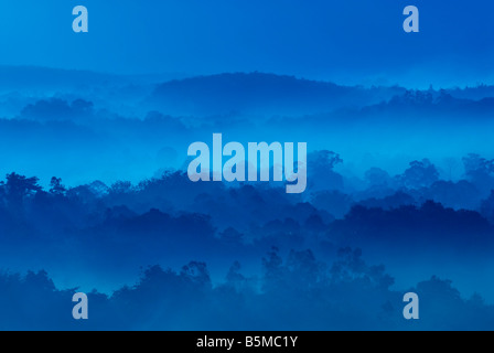 Misty morning of hilly area with ray of light Stock Photo