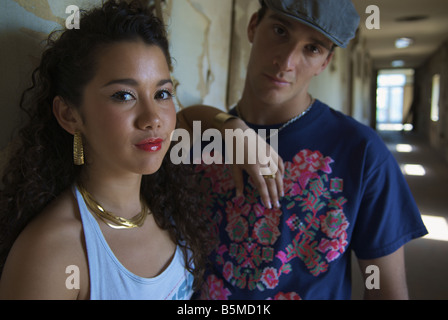 A young man and teenage girl in a hallway Stock Photo