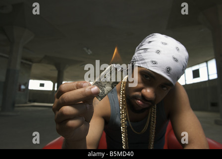 A young man burning a dollar bill Stock Photo