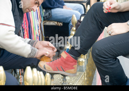 Turkey Istanbul Shoeshine stand female client having her shoes polished Stock Photo