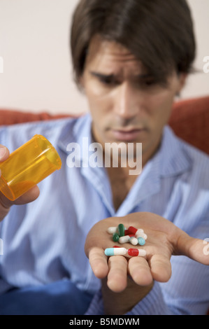 A man with a hand full of pills Stock Photo