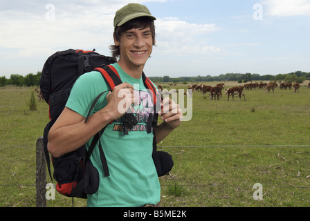 A male backpacker in a cattle pasture Stock Photo