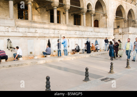 Turkey Istanbul The New Masque Yeni Camii adjacent to the Spice Bazaar Men cleansing themselves by washing their feet Stock Photo