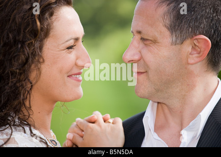bride and groom looking each others eyes, outdoors shot Stock Photo
