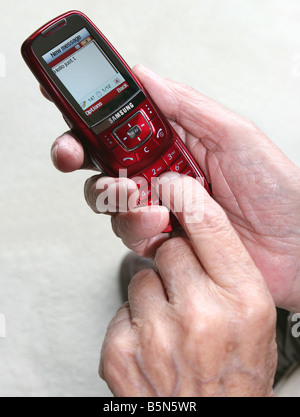 Elderly man using mobile phone to send text message Stock Photo