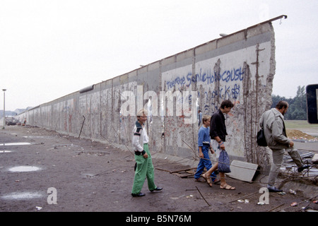 A family crossing through the Berlin Wall near the Brandenburg Gate in 1990 Stock Photo