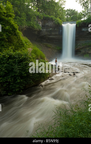 A YOUNG WOMAN STANDING NEAR MINNEHAHA FALLS MINNEAPOLIS MINNESOTA Stock Photo