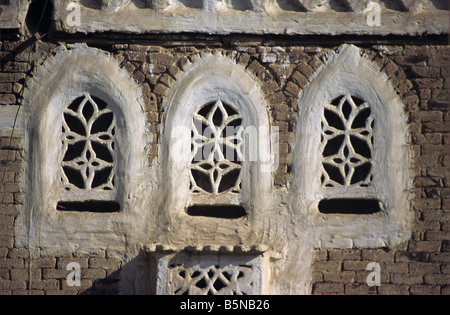 Window Details of Three Arched Windows with Lattice Work Screens   on Mud or Abode Tower House Sana'a Yemen Stock Photo