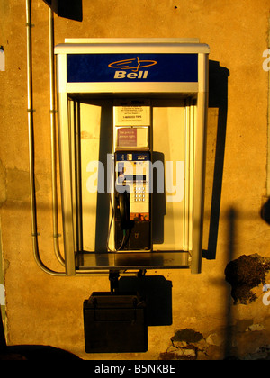 A North American style public telephone booth illuminated by the rising sun Stock Photo