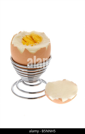 Boiled egg sitting in egg cup with top cut off Stock Photo