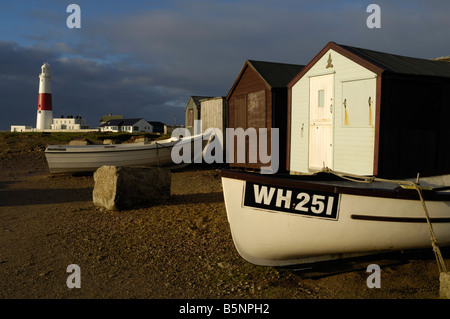 Fishermen's huts at Portland Bill, with fishing boats and lighthouse in background Stock Photo