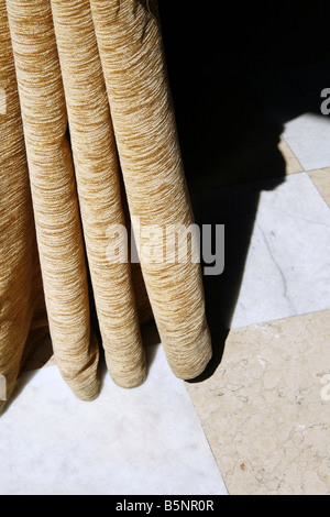 detail of folds long yellow brown curtains drapes in room Stock Photo