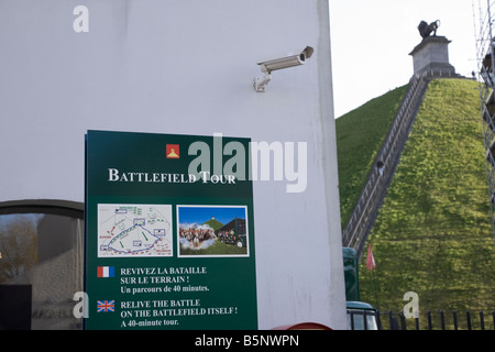 Information sign outside the visitors' centre at the site of the Battle of Waterloo. Lion's Mound hill (Butte du Lion's) at back Stock Photo