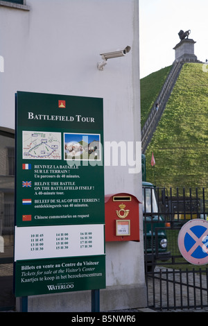 Information sign outside the visitors' centre at the site of the Battle of Waterloo. Lion's Mound hill (Butte du Lion's) at back Stock Photo