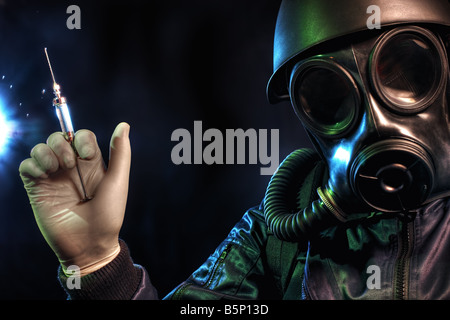 Gas masked man holding a syringe Stock Photo