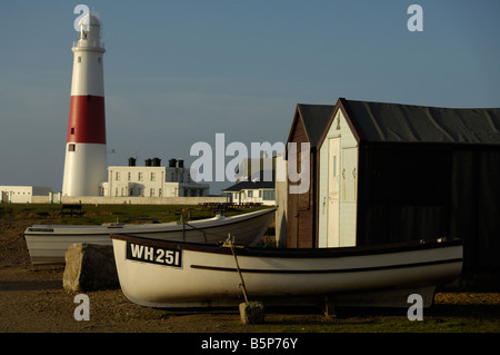 Fishermen's huts at Portland Bill, with fishing boats and lighthouse in background Stock Photo