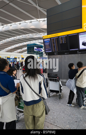 passengers looking at departure announcement board, Terminal 5, Heathrow, London, England Stock Photo