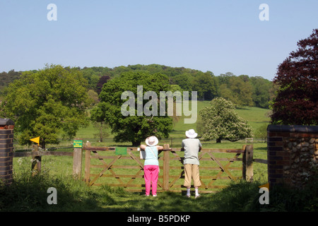 Older couple looking over a gate at the English Countryside Stock Photo