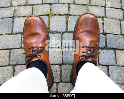A man's feet in brown shoes