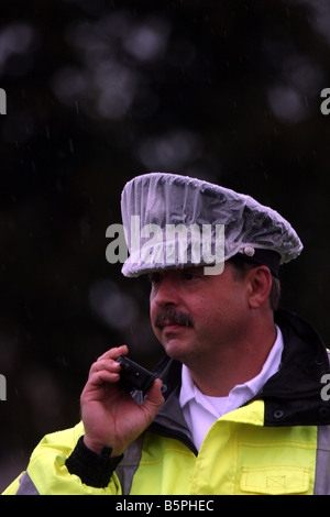 A fire Captain in his rain gear listening to his communication radio Stock Photo