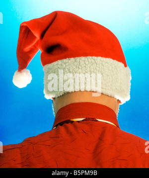 man wearing red white Santa Claus jelly bag cap hat on blue background behind back backside Stock Photo