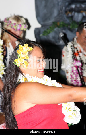 A female Hawaiian Dancer performing with the musical instruments played by the musicians Stock Photo