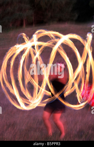 The glow of a female Hawaiian Fire Dancer performing at night Stock Photo