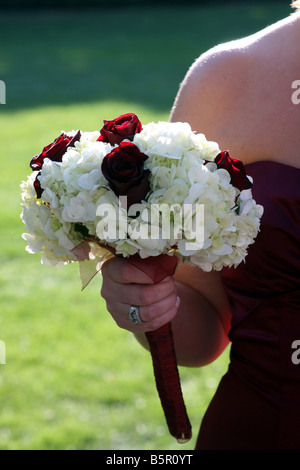 The flower bouquet being held by a bridesmaid while outside in summer Stock Photo