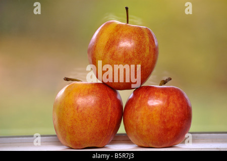 Three apples stacked on a window sill Stock Photo