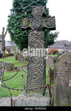 8th Century Saxon Cross in the graveyard of St Lawrence church, Eyam, Derbyshire, England grade I listed Stock Photo