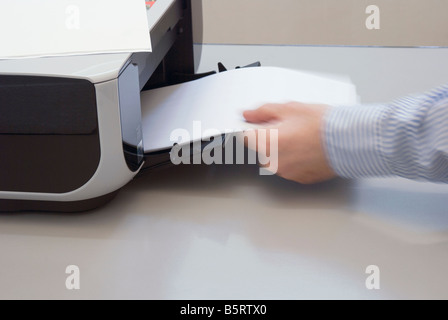 man removing paper from printer Stock Photo