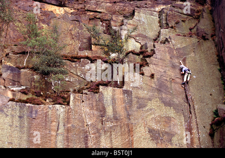 A rock climber climbing a crack in Millstone Quarry near Hathersage and Sheffield in the Peak District National Park, England Stock Photo