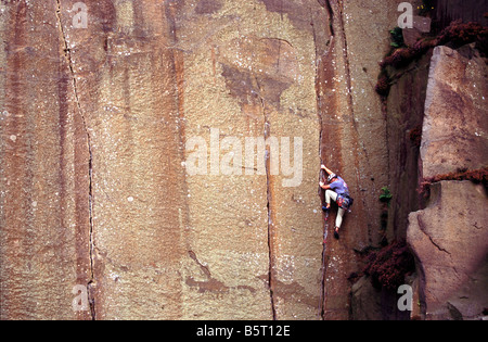 A rock climber climbing a crack in Millstone Quarry near Hathersage and Sheffield in the Peak District National Park, England Stock Photo