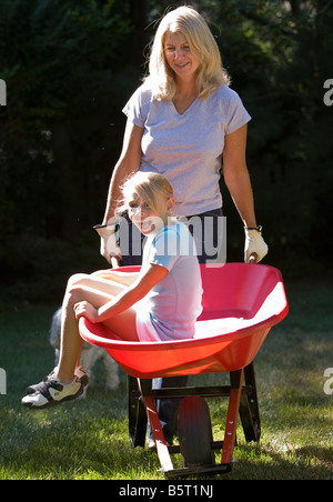 Mother pushing her daughter in a wheelbarrow Stock Photo - Alamy