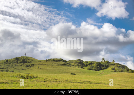 This lava rock cross was erected in 1970 on a grassy hill overlooking Hana Town, Maui, Hawaii. Stock Photo