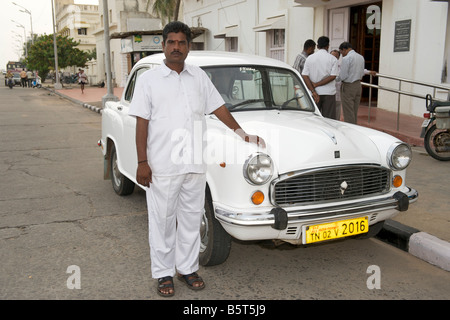 Indian man standing proudly alongside his Ambassador car in Pondicherry India. Stock Photo