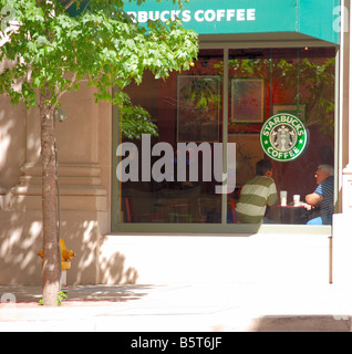 Starbucks with people talking inside Stock Photo