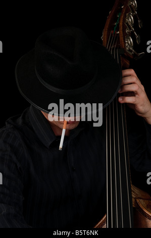 A man plays jazz bass while smoking a cigarette Stock Photo