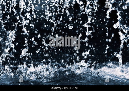 Falling water drops on dark background close up Stock Photo